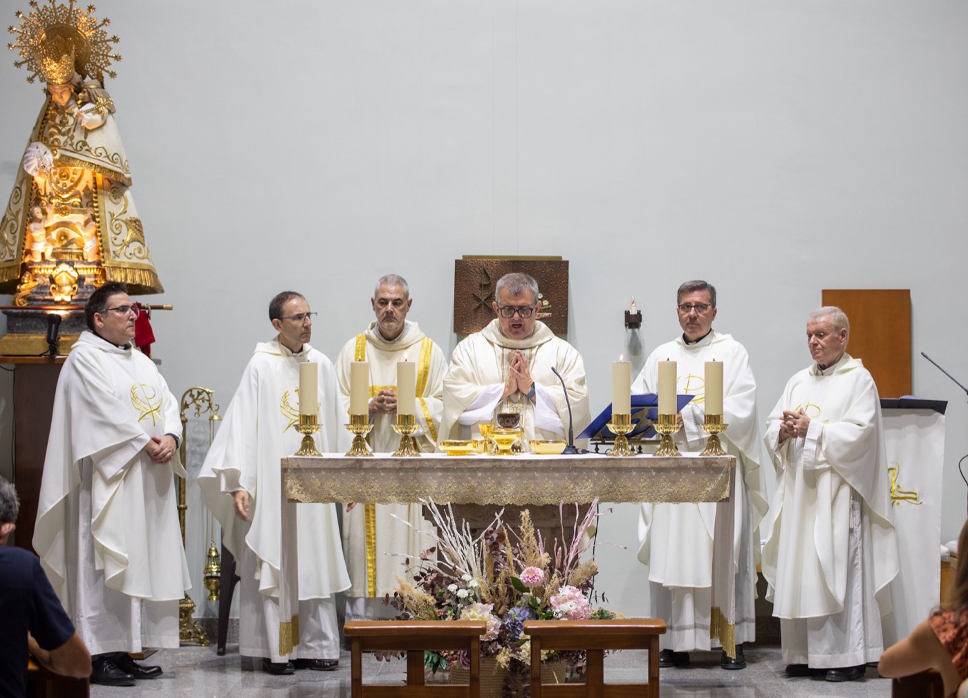 El P. Fernando preside la Eucaristía concelebrada con otros sacerdotes en el altar de la parroquia, junto a la imagen de la Virgen de los Desamparados