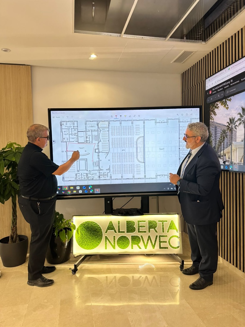 El P. Fernando Mañó señala sobre el plano, en una pantalla, el espacio común del centro parroquial mientras habla con el arquitecto Santiago de Taranco